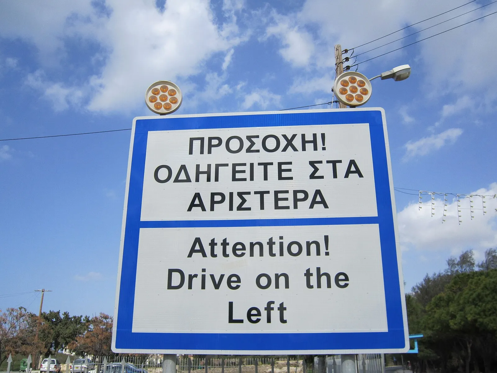 כביש הררי מפותל באי יווני עם נוף לים ולכפר לבן במורד הגבעה